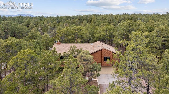 birds eye view of property featuring a view of trees