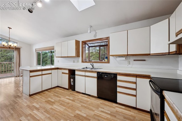 kitchen featuring a peninsula, a sink, white cabinets, light countertops, and black appliances