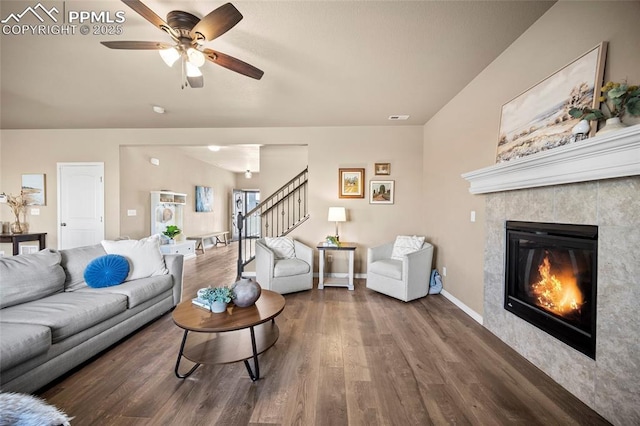 living room with visible vents, baseboards, stairs, a fireplace, and wood finished floors