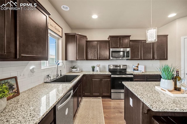 kitchen with light wood finished floors, tasteful backsplash, dark brown cabinetry, stainless steel appliances, and a sink