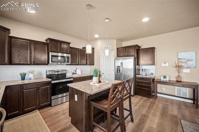 kitchen featuring dark brown cabinets, visible vents, light wood-style floors, and appliances with stainless steel finishes