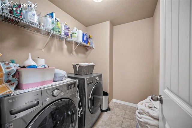 washroom with independent washer and dryer, a textured ceiling, light tile patterned flooring, baseboards, and laundry area