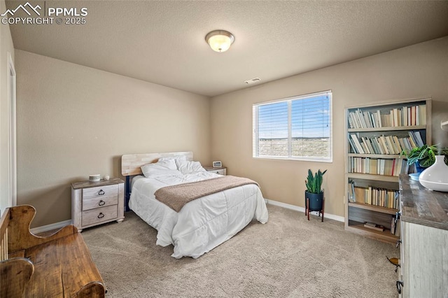 carpeted bedroom featuring visible vents, baseboards, and a textured ceiling