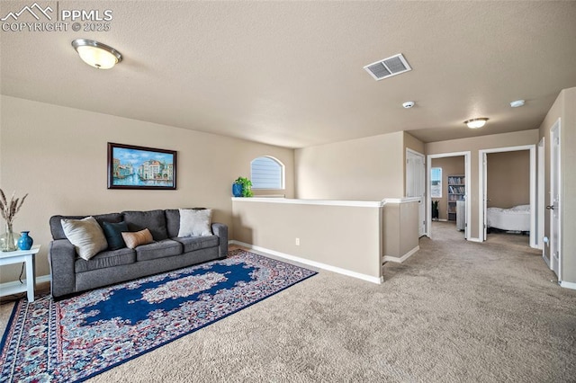 carpeted living room with visible vents, a textured ceiling, and baseboards