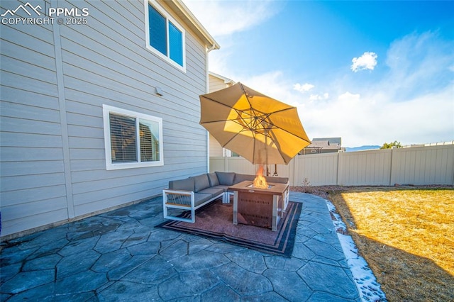 view of patio with an outdoor living space with a fire pit and fence