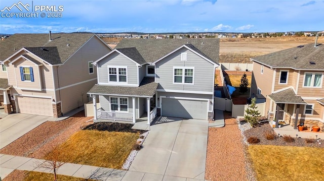 traditional-style home featuring a garage, a residential view, covered porch, and driveway