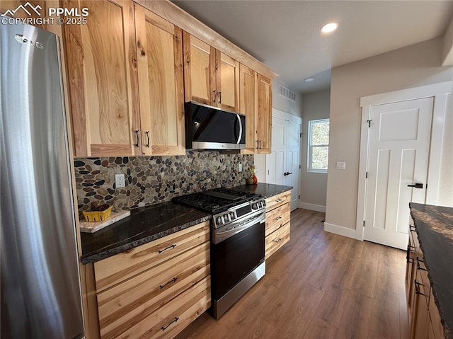 kitchen featuring stainless steel appliances, tasteful backsplash, dark wood finished floors, and visible vents