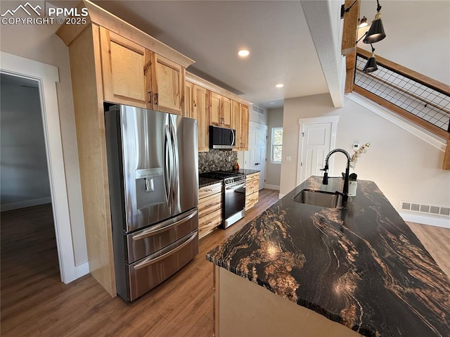 kitchen with visible vents, light wood-style flooring, appliances with stainless steel finishes, light brown cabinets, and a sink