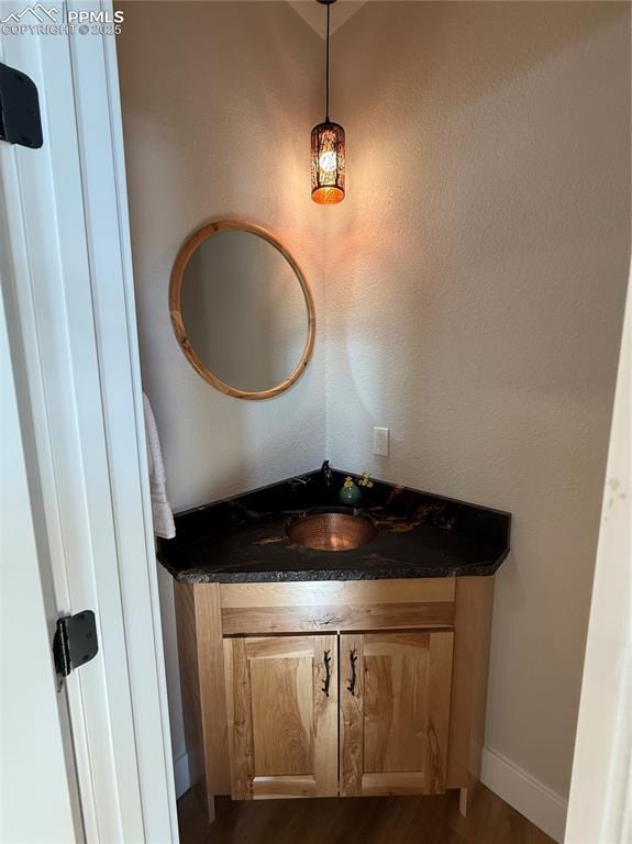 bathroom featuring vanity, baseboards, and wood finished floors