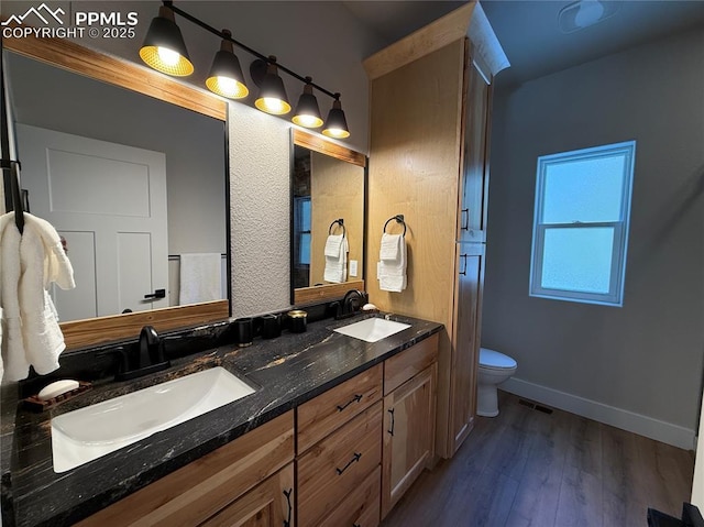 full bath featuring wood finished floors, a sink, toilet, and baseboards