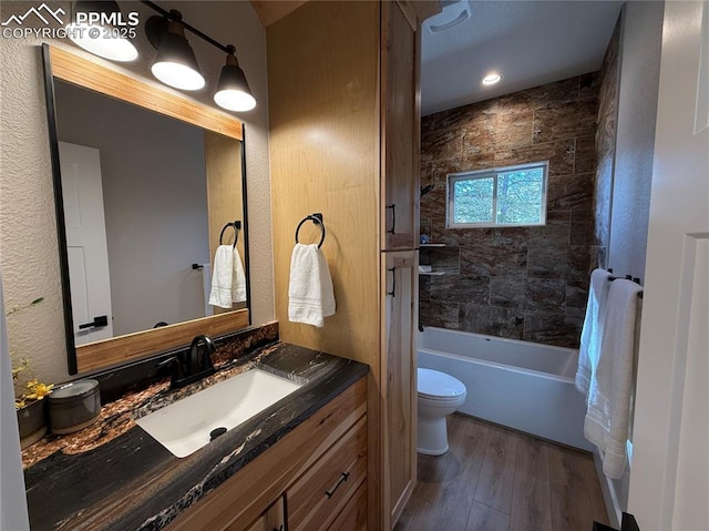 full bath with toilet, shower / washtub combination, wood finished floors, and vanity