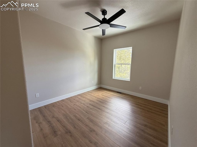 empty room featuring a ceiling fan, a textured ceiling, baseboards, and wood finished floors