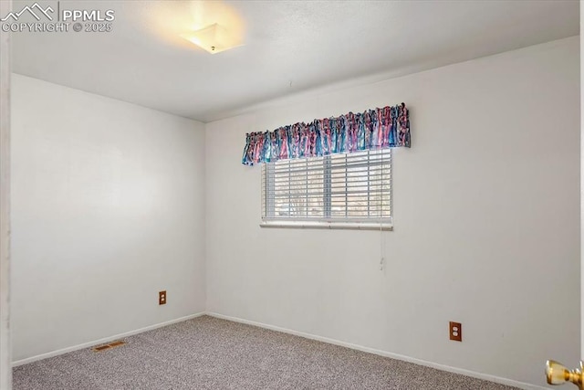 carpeted spare room featuring visible vents and baseboards