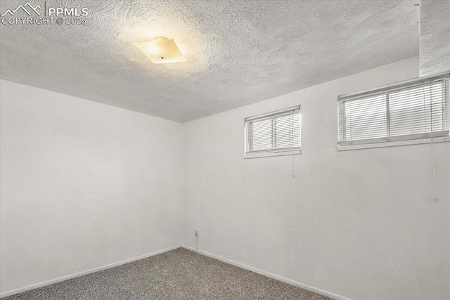 unfurnished room featuring carpet floors, baseboards, and a textured ceiling