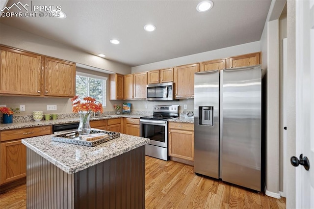 kitchen featuring appliances with stainless steel finishes, recessed lighting, light wood finished floors, and light stone countertops