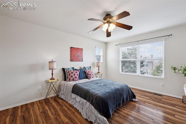 bedroom featuring a ceiling fan, baseboards, and wood finished floors