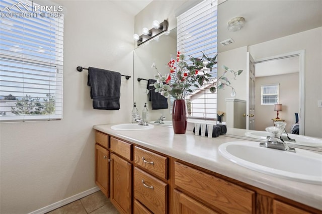 full bathroom with double vanity, a sink, a wealth of natural light, and tile patterned floors