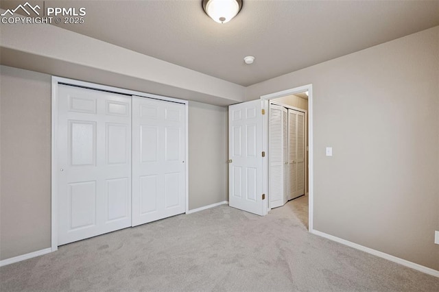 unfurnished bedroom with a closet, carpet flooring, and baseboards