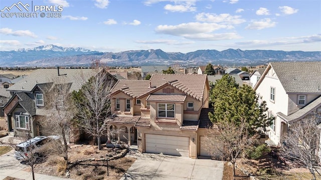 view of front of house featuring driveway, a mountain view, and a tiled roof