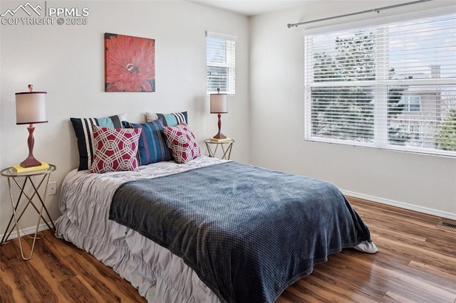 bedroom with wood finished floors and baseboards