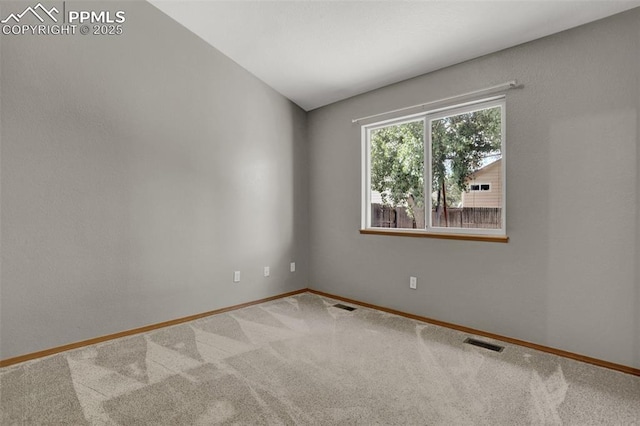 unfurnished room with carpet floors, visible vents, and baseboards