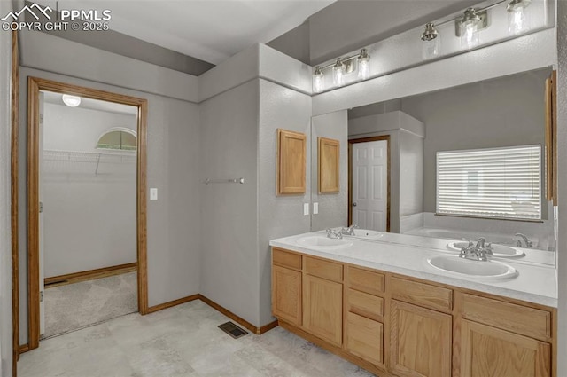 bathroom featuring double vanity, visible vents, a bath, a spacious closet, and a sink