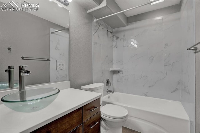 bathroom with a textured wall, vanity, shower / tub combination, and toilet