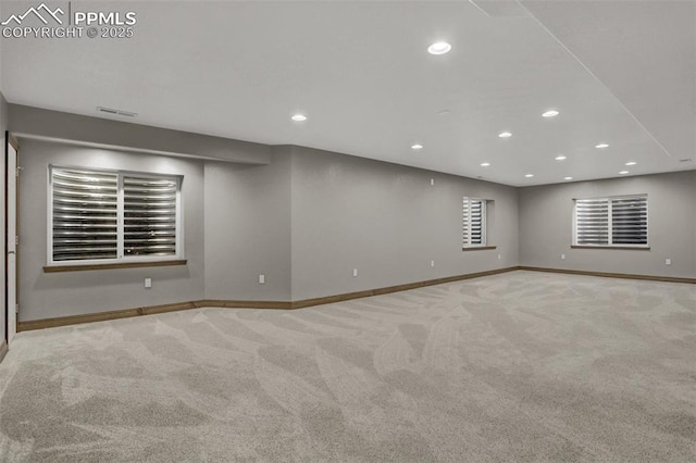 basement with recessed lighting, light colored carpet, visible vents, and baseboards