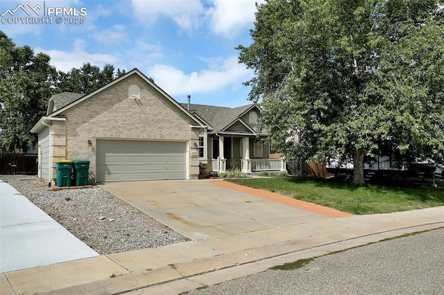 view of front facade featuring a porch, a garage, brick siding, driveway, and a front lawn