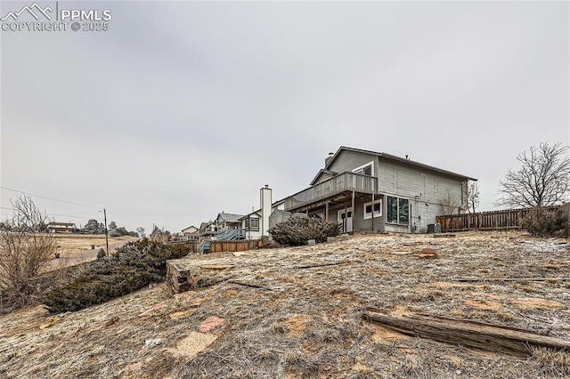 rear view of property with fence and a deck