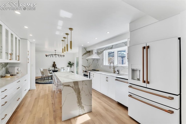 kitchen featuring glass insert cabinets, white appliances, white cabinets, and a kitchen island