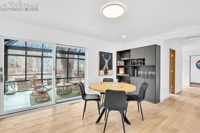 dining room featuring light wood finished floors, baseboards, and visible vents