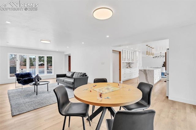 dining room with baseboards, recessed lighting, and light wood-style floors