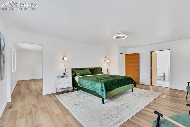 bedroom with light wood-type flooring and baseboards