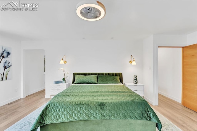 bedroom with baseboards, visible vents, and wood finished floors