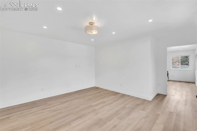 spare room with baseboards, light wood-type flooring, and recessed lighting