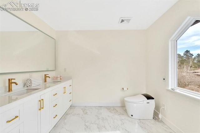 bathroom featuring double vanity, marble finish floor, baseboards, and a sink