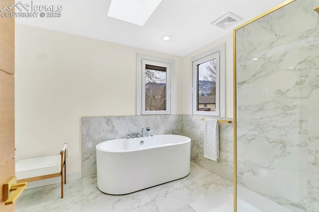 full bath with recessed lighting, a skylight, visible vents, a freestanding bath, and marble finish floor