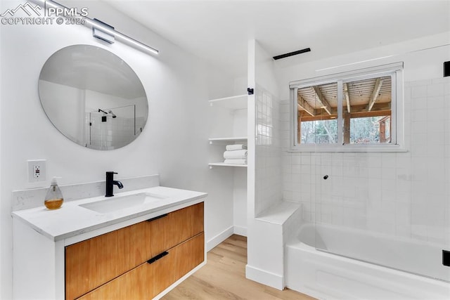 full bath featuring bathtub / shower combination, vanity, baseboards, and wood finished floors