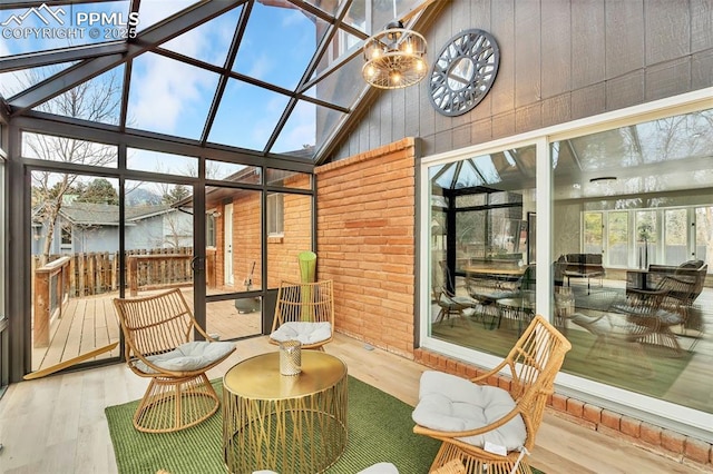 sunroom featuring lofted ceiling and an inviting chandelier