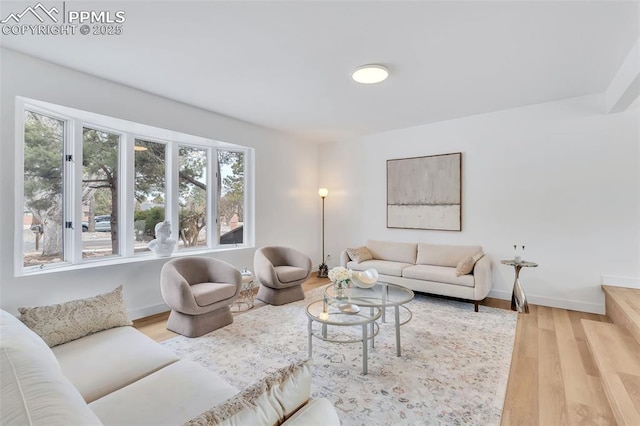 living area with baseboards and wood finished floors