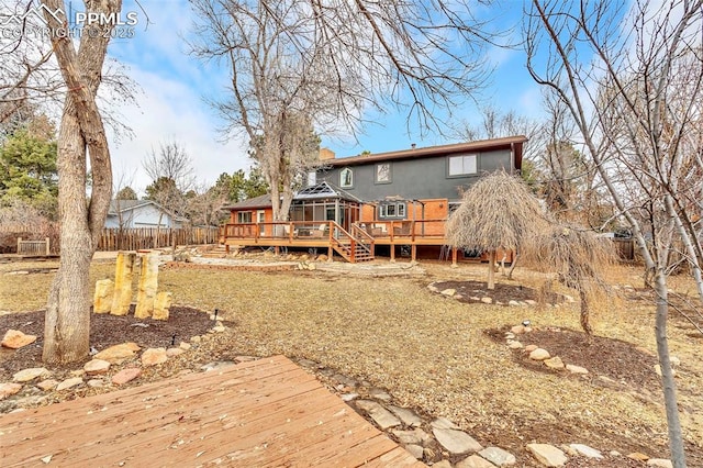 rear view of property with a gazebo, a chimney, a wooden deck, and fence