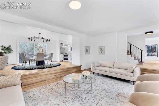 living room featuring baseboards, wine cooler, stairway, and wood finished floors