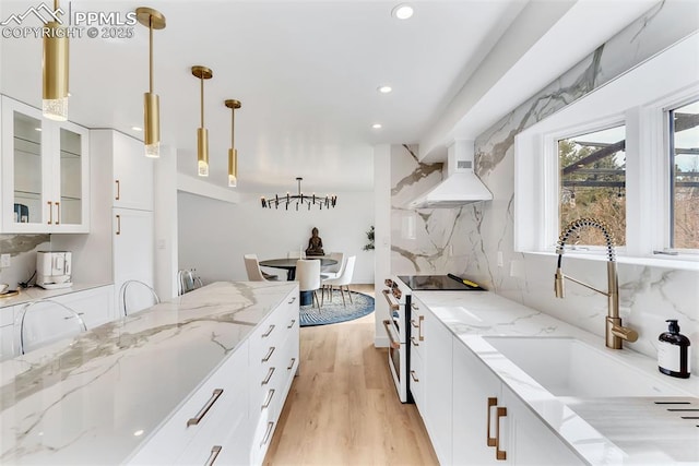 kitchen featuring hanging light fixtures, glass insert cabinets, white cabinets, premium range hood, and high end white range