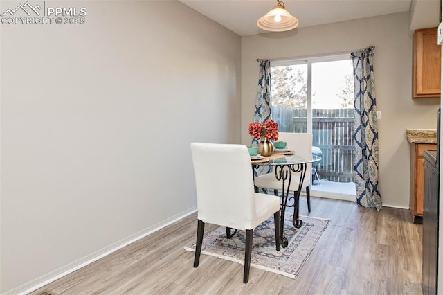 dining space featuring light wood-style floors and baseboards