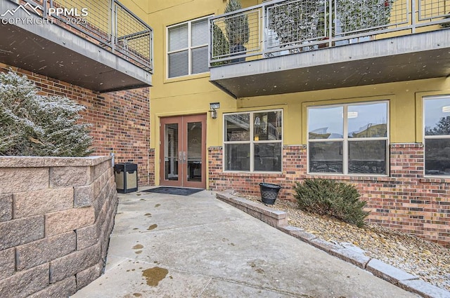 property entrance featuring a patio area and brick siding