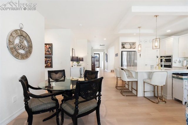 dining area featuring light wood-style floors, baseboards, and recessed lighting