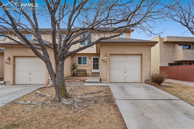 view of front facade with an attached garage, concrete driveway, and stucco siding