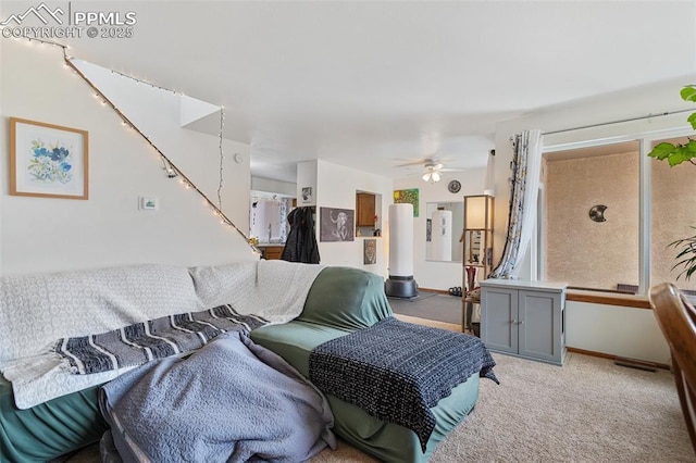 living room featuring baseboards, a ceiling fan, and light colored carpet