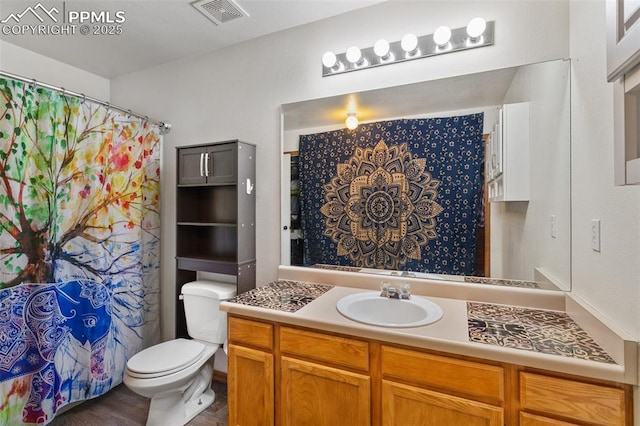 bathroom featuring curtained shower, visible vents, vanity, and toilet